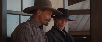 Movie still from “Appaloosa” (2008), directed by Ed Harris – A couple of men wearing hats standing next to each other; Close Up shot, Low angle