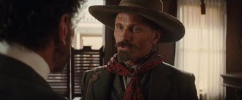 Movie still from “Appaloosa” (2008), directed by Ed Harris – A man with a long beard wearing a cowboy hat; Close Up shot, Over the shoulder angle
