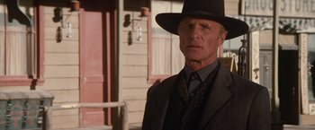 Movie still from “Appaloosa” (2008), directed by Ed Harris – An older man wearing a suit and a hat; Close Up shot, Low angle