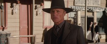 Movie still from “Appaloosa” (2008), directed by Ed Harris – A man wearing a suit and a black hat; Close Up shot, Low angle