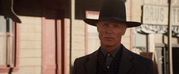Movie still from “Appaloosa” (2008), directed by Ed Harris – An older man wearing a suit and a hat; Close Up shot, Low angle
