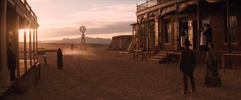 Movie still from “Appaloosa” (2008), directed by Ed Harris – An old western style building with a windmill in the background; Extreme Wide shot, Low angle
