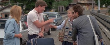 Movie still from “April Fool's Day” (1986), directed by Fred Walton – A group of people standing on the side of a road; Medium shot, Over the shoulder angle