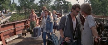 Movie still from “April Fool's Day” (1986), directed by Fred Walton – A group of people walking down a ramp with suitcases; Wide shot, Over the shoulder angle