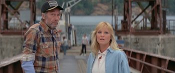 Movie still from “April Fool's Day” (1986), directed by Fred Walton – A man and a woman standing next to each other on a pier; Medium shot, Low angle