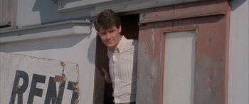 Movie still from “April Fool's Day” (1986), directed by Fred Walton – A man standing in a doorway of an old building; Close Up shot, Low angle