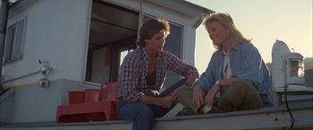 Movie still from “April Fool's Day” (1986), directed by Fred Walton – A man and a woman sitting on the back of a truck; Medium shot, Low angle
