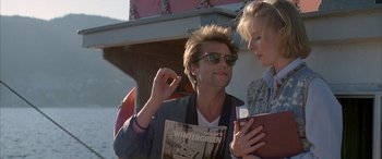 Movie still from “April Fool's Day” (1986), directed by Fred Walton – A man and a woman are looking at each other while holding a book; Close Up shot, Over the shoulder angle