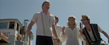 Movie still from “April Fool's Day” (1986), directed by Fred Walton – A group of people standing next to each other on a field; Medium shot, Low angle