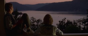 Movie still from “April Fool's Day” (1986), directed by Fred Walton – A woman sitting on a bench looking out at a body of water; Wide shot, High angle
