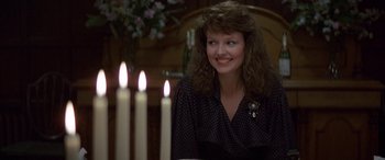 Movie still from “April Fool's Day” (1986), directed by Fred Walton – A woman sitting in front of candles in a room; Close Up shot, Over the shoulder angle