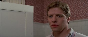 Movie still from “April Fool's Day” (1986), directed by Fred Walton – A young man looking into a mirror in a bathroom; Close Up shot, Low angle