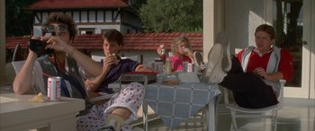 Movie still from “April Fool's Day” (1986), directed by Fred Walton – A man and a woman sitting at a table with drinks; Wide shot, Low angle