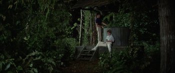 Movie still from “April Fool's Day” (1986), directed by Fred Walton – A man and a boy standing on steps in the woods; Wide shot, High angle