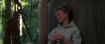 Movie still from “April Fool's Day” (1986), directed by Fred Walton – A woman sitting in a chair smiling at the camera; Medium shot, Over the shoulder angle