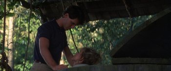 Movie still from “April Fool's Day” (1986), directed by Fred Walton – A man and a woman standing next to each other under a canopy; Medium shot, Low angle