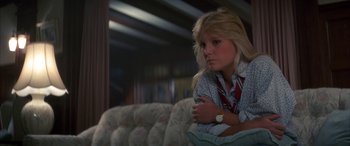 Movie still from “April Fool's Day” (1986), directed by Fred Walton – A woman sitting on top of a couch in front of a mirror; Close Up shot, Low angle