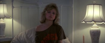 Movie still from “April Fool's Day” (1986), directed by Fred Walton – A young woman is sitting in a bed; Close Up shot, Low angle
