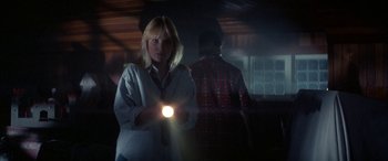 Movie still from “April Fool's Day” (1986), directed by Fred Walton – A woman is holding a light in her hand; Medium shot, Low angle
