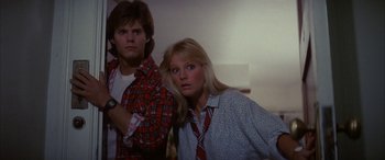 Movie still from “April Fool's Day” (1986), directed by Fred Walton – A man and a woman standing next to each other; Medium shot, Low angle