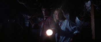 Movie still from “April Fool's Day” (1986), directed by Fred Walton – A man and a woman are holding a flashlight; Medium shot, Low angle