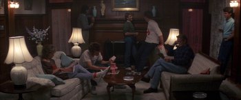 Movie still from “April Fool's Day” (1986), directed by Fred Walton – A group of people sitting around a living room; Wide shot, High angle