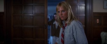 Movie still from “April Fool's Day” (1986), directed by Fred Walton – A woman in a tie standing in front of a mirror; Close Up shot, Low angle