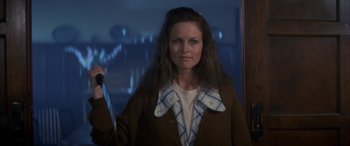 Movie still from “April Fool's Day” (1986), directed by Fred Walton – A woman holding a knife in her hand; Medium shot, Low angle