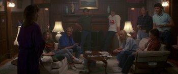 Movie still from “April Fool's Day” (1986), directed by Fred Walton – A group of people sitting around a living room; Wide shot, Low angle