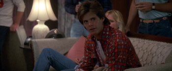 Movie still from “April Fool's Day” (1986), directed by Fred Walton – A man sitting on a couch in front of a woman; Close Up shot, Over the shoulder angle