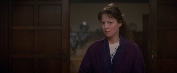 Movie still from “April Fool's Day” (1986), directed by Fred Walton – A young woman in a purple robe looks at the camera; Close Up shot, Over the shoulder angle