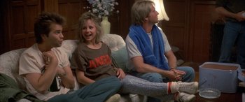 Movie still from “April Fool's Day” (1986), directed by Fred Walton – A woman and a man sitting on a couch; Medium shot, High angle