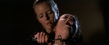 Movie still from “April Fool's Day” (1986), directed by Fred Walton – A woman holding a pair of scissors over a woman's face; Close Up shot, Low angle