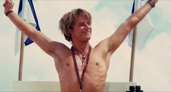 Movie still from “Aquamarine” (2006), directed by Elizabeth Allen Rosenbaum – A man with his arms raised in the air; Medium shot, Low angle