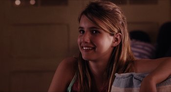 Movie still from “Aquamarine” (2006), directed by Elizabeth Allen Rosenbaum – A young woman smiles brightly while sitting in a chair; Close Up shot, Over the shoulder angle