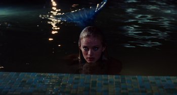 Movie still from “Aquamarine” (2006), directed by Elizabeth Allen Rosenbaum – A woman in the water with a mermaid tail in the background; Medium shot, Over the shoulder angle