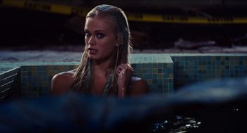 Movie still from “Aquamarine” (2006), directed by Elizabeth Allen Rosenbaum – A beautiful young blond woman sitting in a pool; Medium shot, Over the shoulder angle
