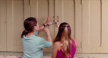 Movie still from “Aquamarine” (2006), directed by Elizabeth Allen Rosenbaum – Two young girls are playing with a door knob; Medium shot, Over the shoulder angle