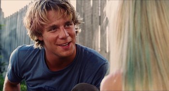 Movie still from “Aquamarine” (2006), directed by Elizabeth Allen Rosenbaum – A man with blonde long hair and a blue shirt; Close Up shot, Over the shoulder angle