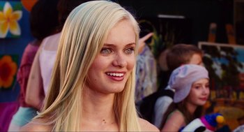 Movie still from “Aquamarine” (2006), directed by Elizabeth Allen Rosenbaum – A beautiful blonde woman with blue eyes smiling for the camera; Close Up shot, Over the shoulder angle
