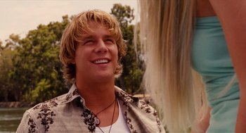 Movie still from “Aquamarine” (2006), directed by Elizabeth Allen Rosenbaum – A man with blonde hair smiling at the camera; Close Up shot, Over the shoulder angle