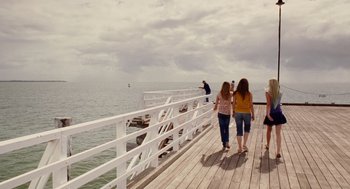 Movie still from “Aquamarine” (2006), directed by Elizabeth Allen Rosenbaum – A group of people walking on a pier near the ocean; Extreme Wide shot, High angle
