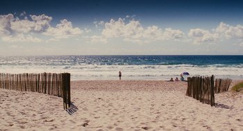 Movie still from “Aquamarine” (2006), directed by Elizabeth Allen Rosenbaum – A person standing on a beach near the ocean; Extreme Wide shot, High angle