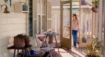 Movie still from “Aquamarine” (2006), directed by Elizabeth Allen Rosenbaum – A woman standing on a porch looking out a screen door; Wide shot, Low angle