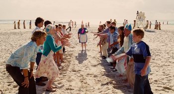 Movie still from “Aquamarine” (2006), directed by Elizabeth Allen Rosenbaum – A group of people standing on a sandy beach; Wide shot, High angle