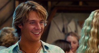 Movie still from “Aquamarine” (2006), directed by Elizabeth Allen Rosenbaum – A young man smiling while wearing a white shirt; Close Up shot, Over the shoulder angle