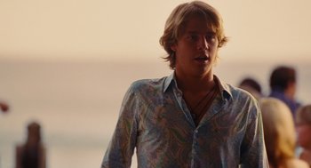 Movie still from “Aquamarine” (2006), directed by Elizabeth Allen Rosenbaum – A man with long blonde hair wearing a blue shirt; Medium shot, Low angle