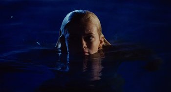 Movie still from “Aquamarine” (2006), directed by Elizabeth Allen Rosenbaum – A woman with blonde hair floating in a body of water at night; Close Up shot, Low angle