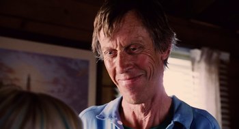 Movie still from “Aquamarine” (2006), directed by Elizabeth Allen Rosenbaum – An older man is smiling for the camera; Close Up shot, Over the shoulder angle