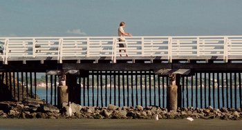 Movie still from “Aquamarine” (2006), directed by Elizabeth Allen Rosenbaum – A man walking across a bridge near the water; Extreme Wide shot, Low angle